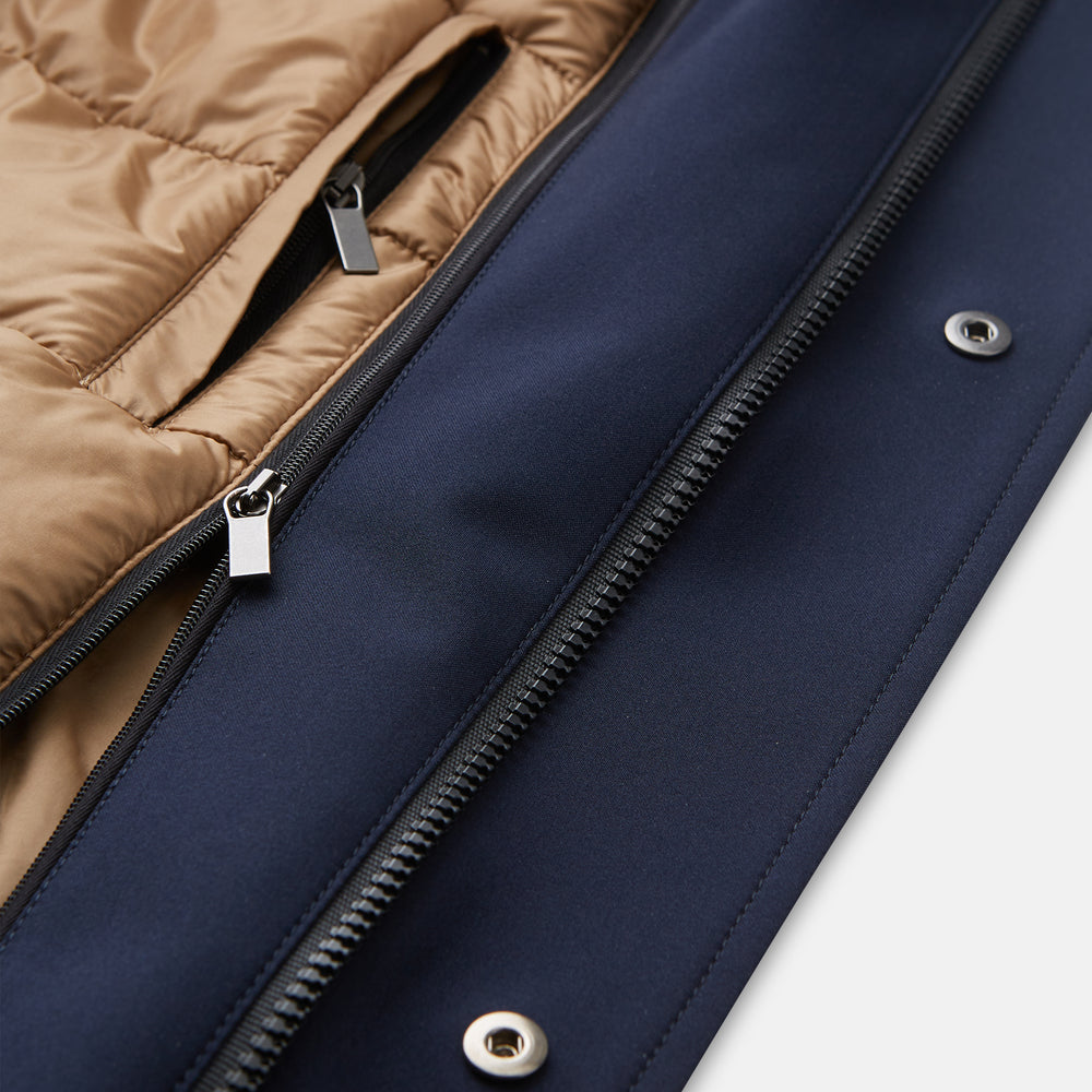 The Turnbull & Asser Navy Walter Sealup Parka with Detachable Liner features silver snap buttons, front flap pockets, and a drawstring hem. Styled against a white background, this waterproof parka offers both elegance and practicality for wet weather.