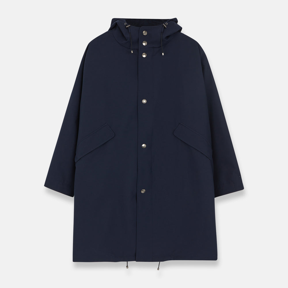 The Turnbull & Asser Navy Walter Sealup Parka with Detachable Liner features silver snap buttons, front flap pockets, and a drawstring hem. Styled against a white background, this waterproof parka offers both elegance and practicality for wet weather.