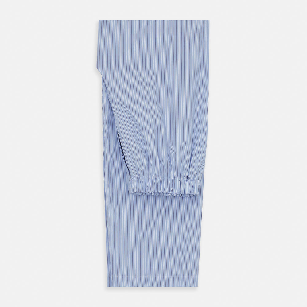 A man stands barefoot against a plain background, wearing a white short-sleeve T-shirt and Turnbull & Asser Blue Stripe Cotton Pyjama Trousers in a contemporary fit, looking straight ahead with a neutral expression.