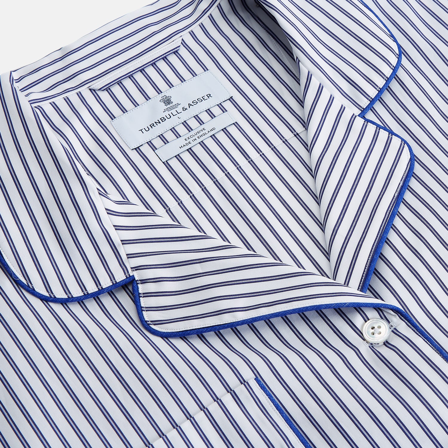 View 2 of product The Women's Dara Navy Stripe Pyjama Set by Turnbull & Asser features a long-sleeve button-up shirt with chest pocket and drawstring pants in premium cotton, shown neatly on a white background.