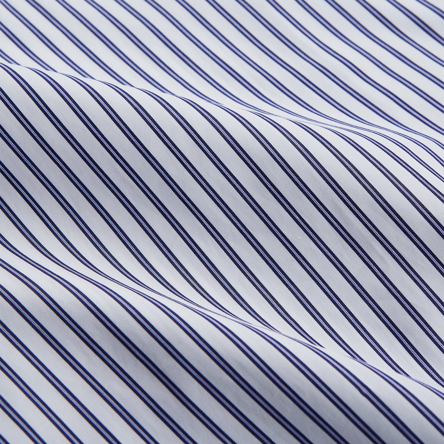 View 5 of product The Women's Dara Navy Stripe Pyjama Set by Turnbull & Asser features a long-sleeve button-up shirt with chest pocket and drawstring pants in premium cotton, shown neatly on a white background.