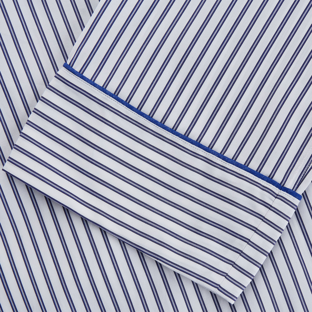 The Women's Dara Navy Stripe Pyjama Set by Turnbull & Asser features a long-sleeve button-up shirt with chest pocket and drawstring pants in premium cotton, shown neatly on a white background.
