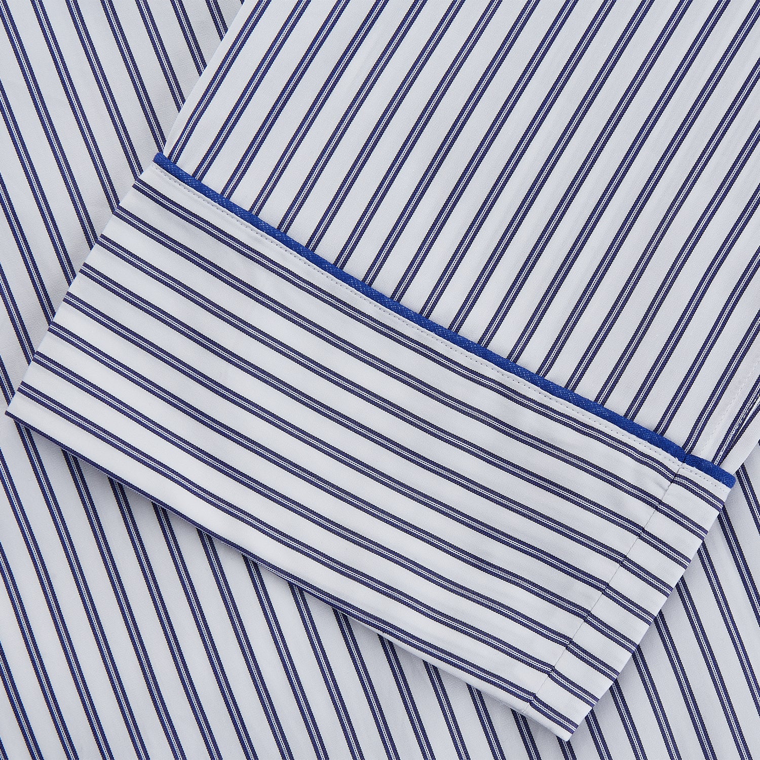 View 3 of product The Women's Dara Navy Stripe Pyjama Set by Turnbull & Asser features a long-sleeve button-up shirt with chest pocket and drawstring pants in premium cotton, shown neatly on a white background.