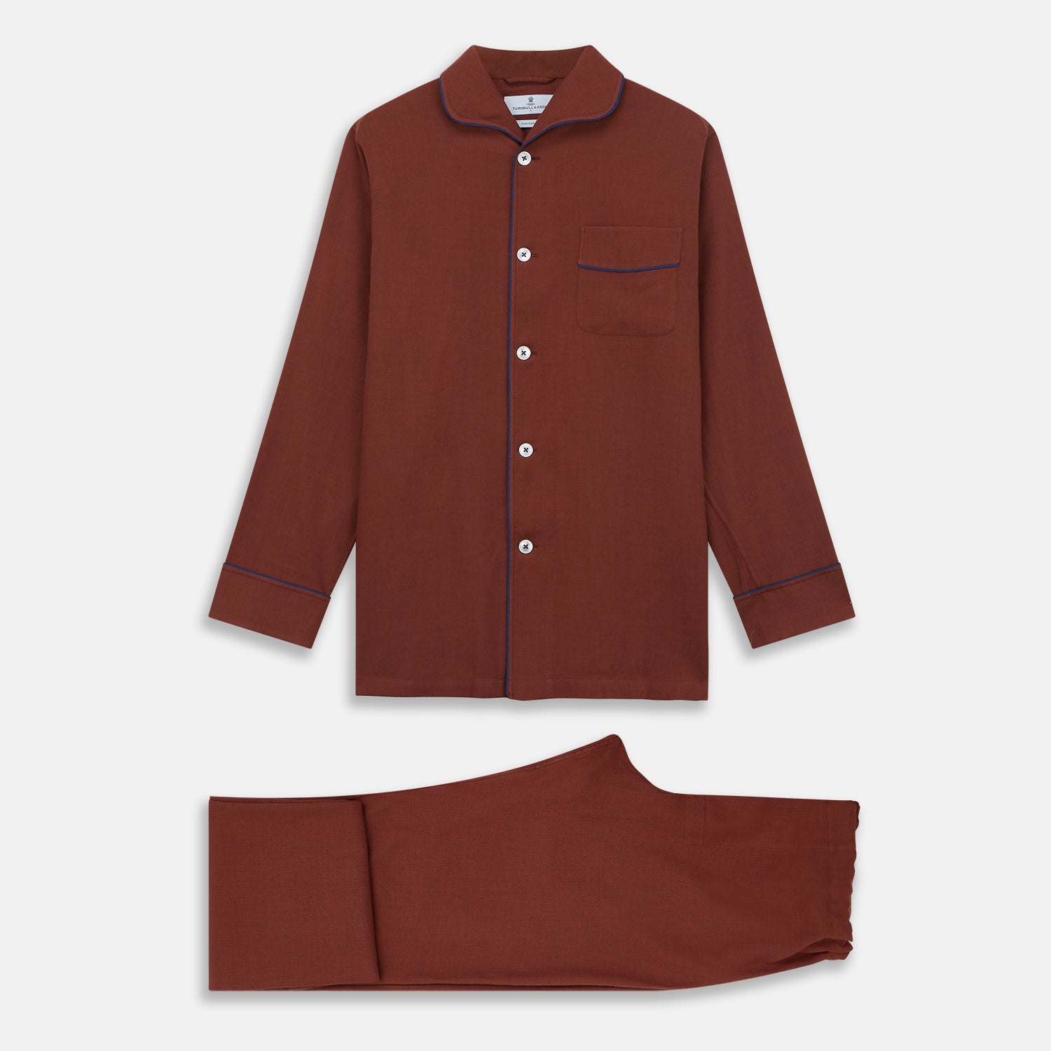 View 2 of product The Turnbull & Asser Red Cotton-Cashmere Pyjama Set features a rust-red long-sleeve button-up top with chest pocket and matching waist-tied pants, shown on a plain white background.