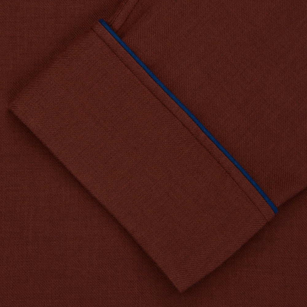 The Turnbull & Asser Red Cotton-Cashmere Pyjama Set features a rust-red long-sleeve button-up top with chest pocket and matching waist-tied pants, shown on a plain white background.