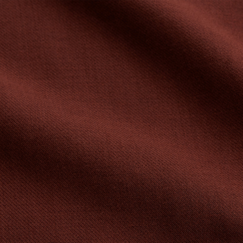 The Turnbull & Asser Red Cotton-Cashmere Pyjama Set features a rust-red long-sleeve button-up top with chest pocket and matching waist-tied pants, shown on a plain white background.