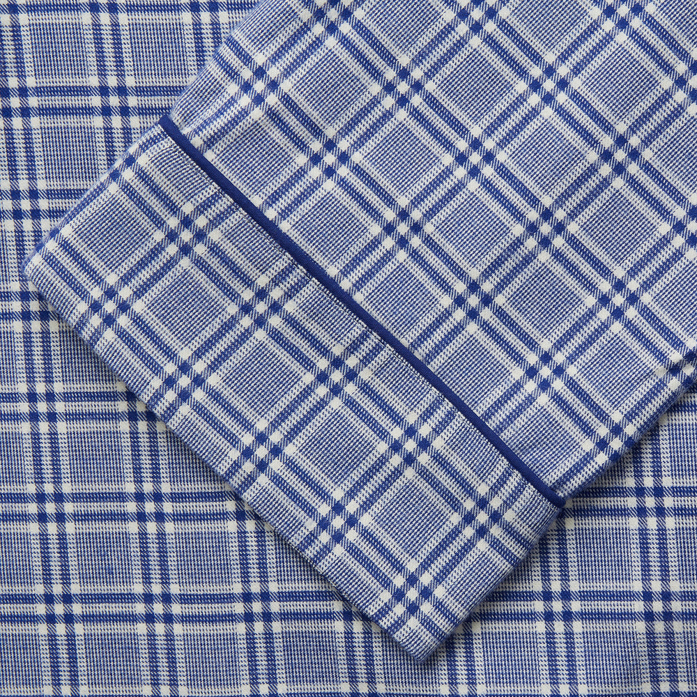 The Turnbull & Asser Blue Check Modern Cotton Pyjama Set features a long-sleeve button-up top and matching pants, crafted from thicker cotton for added comfort, shown against a white background.