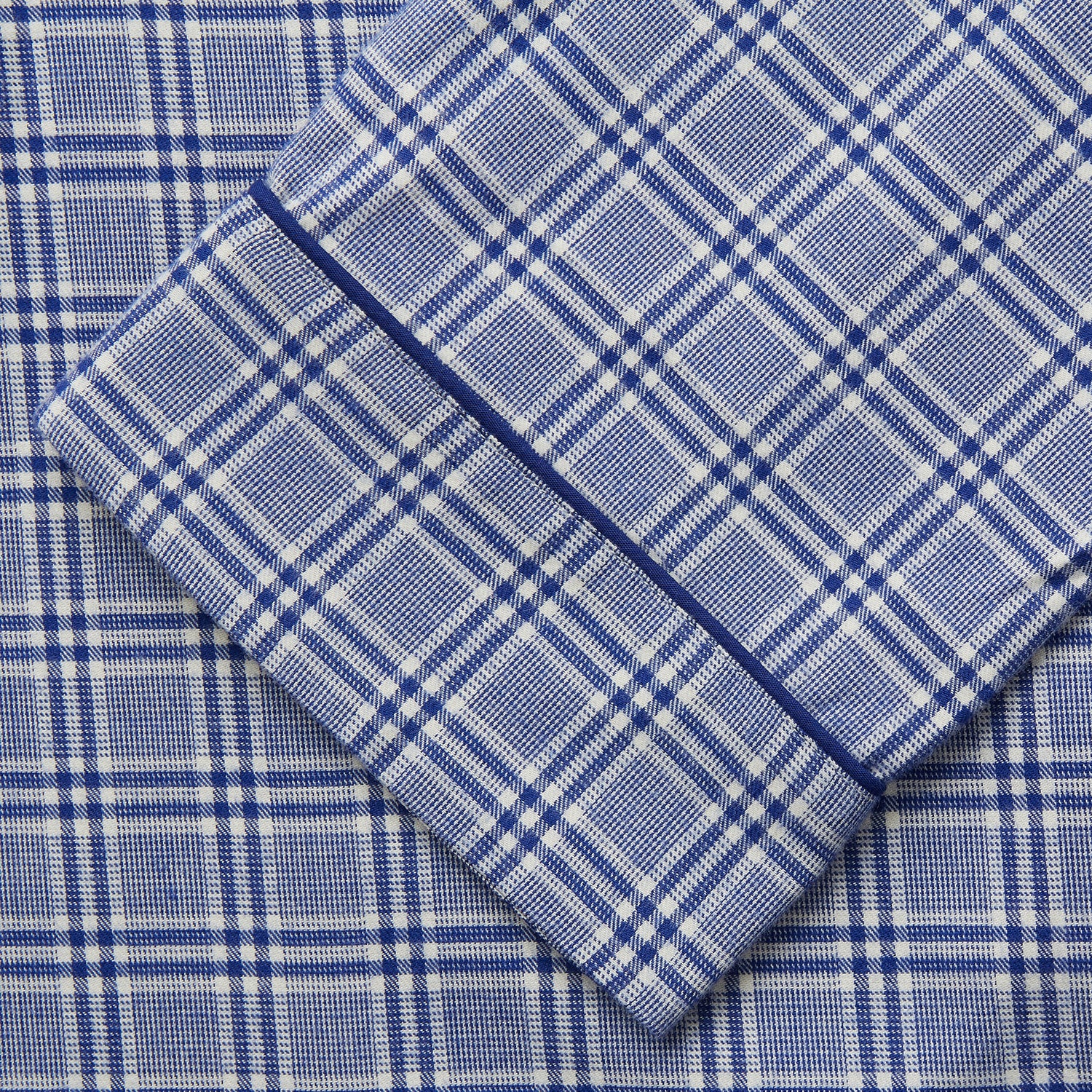 View 3 of product The Turnbull & Asser Blue Check Modern Cotton Pyjama Set features a long-sleeve button-up top and matching pants, crafted from thicker cotton for added comfort, shown against a white background.