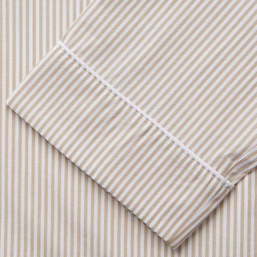 The Turnbull & Asser Sand Bengal Stripe Modern Fit Cotton Pyjama Set features cream-colored striped Italian cotton, with a long-sleeved button-up top and matching drawstring pants, neatly displayed against a white background.