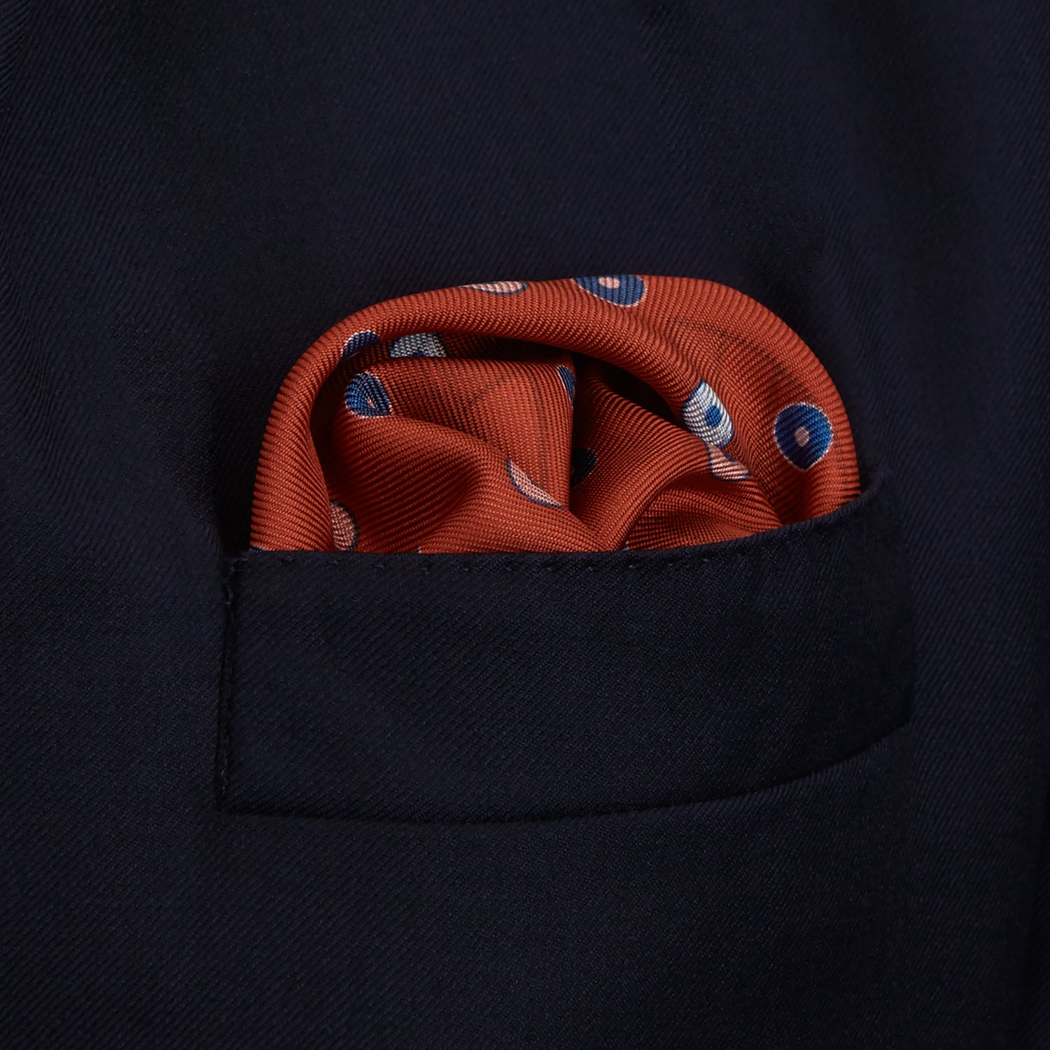View 6 of product The Turnbull & Asser Red Windsurfer Double-Faced Silk Print Pocket Square features a vibrant windsurfer pattern on silk with a dark blue border and the brand subtly printed in one corner.
