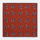 The Turnbull & Asser Red Windsurfer Double-Faced Silk Print Pocket Square features a vibrant windsurfer pattern on silk with a dark blue border and the brand subtly printed in one corner.