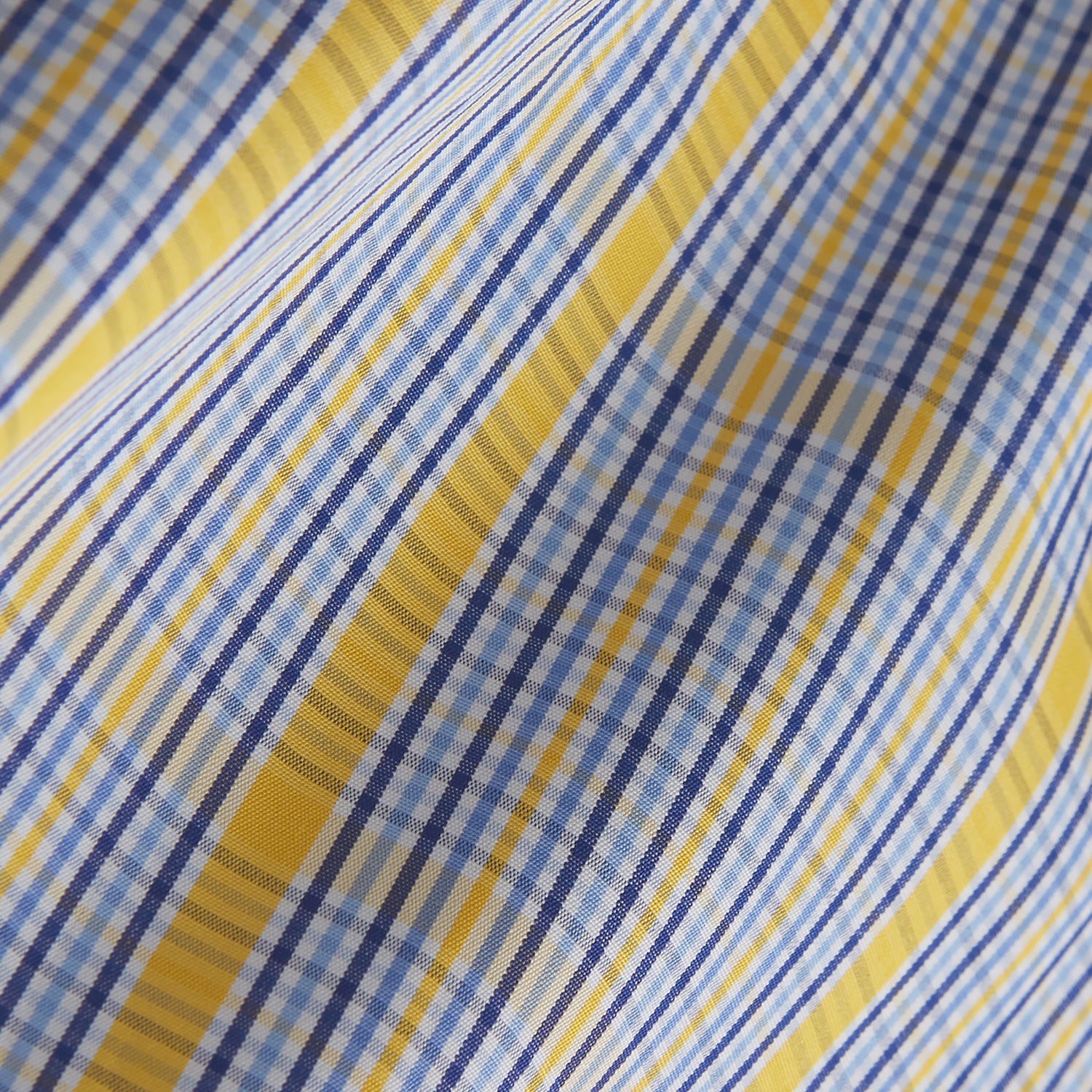 View 6 of product A man stands against a light background, wearing a Turnbull & Asser Yellow and Blue Fancy Check Regular Fit Shirt with T&A Collar, a patterned tie, dark dress pants, and black shoes. He faces forward with hands in pockets and a neutral expression.