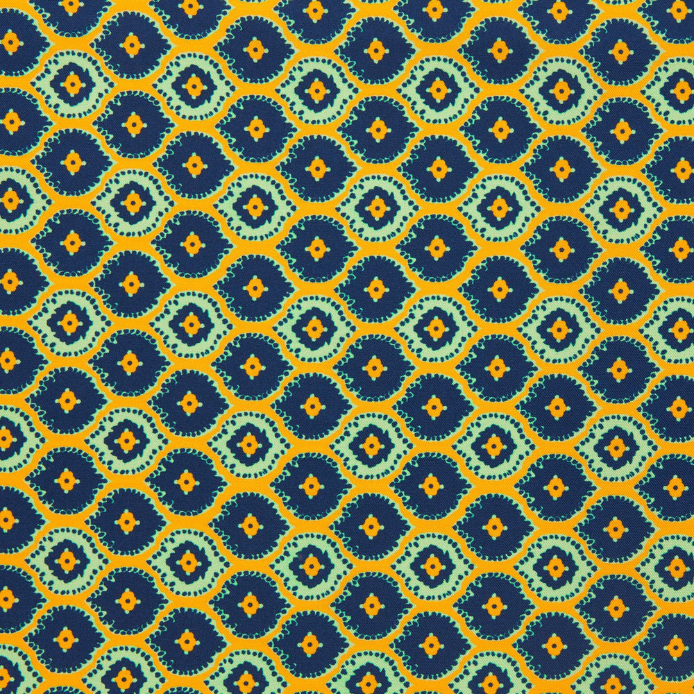 The Yellow Medallion Print Silk Pocket Square by Turnbull & Asser features blue hexagons with ochre yellow centers on a dark blue background, bordered by a dotted ochre yellow frame—a stylish accessory for any suit.