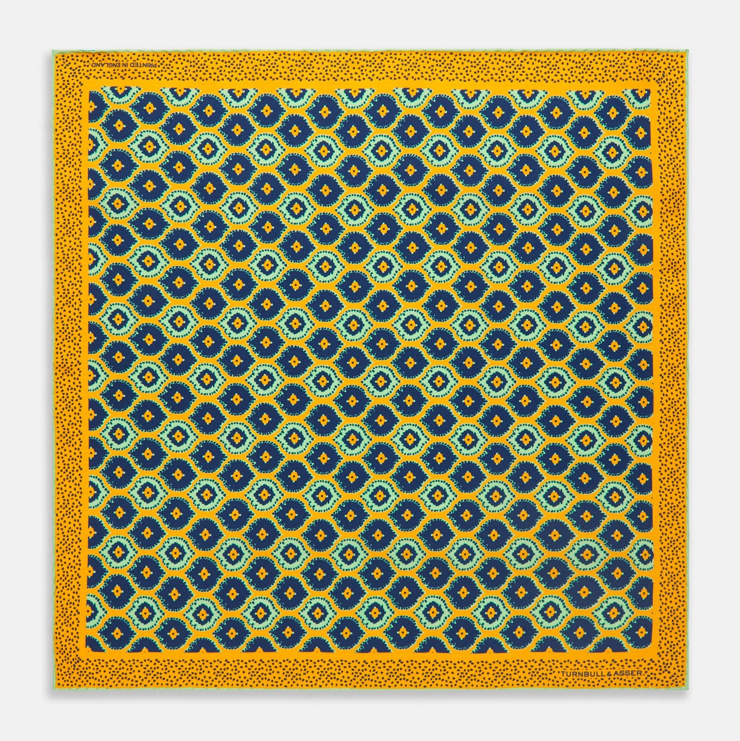 View 1 of product The Yellow Medallion Print Silk Pocket Square by Turnbull & Asser features blue hexagons with ochre yellow centers on a dark blue background, bordered by a dotted ochre yellow frame—a stylish accessory for any suit.