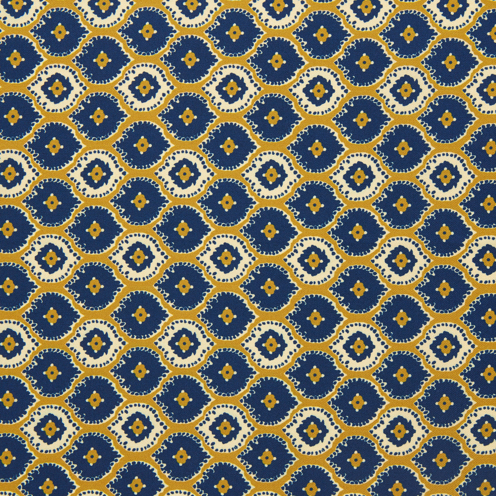 The Tan Medallion Print Silk Pocket Square by Turnbull & Asser features an elegant medallion geometric pattern in blue, white, and gold with central diamond shapes and a gold dotted border on luxurious silk.
