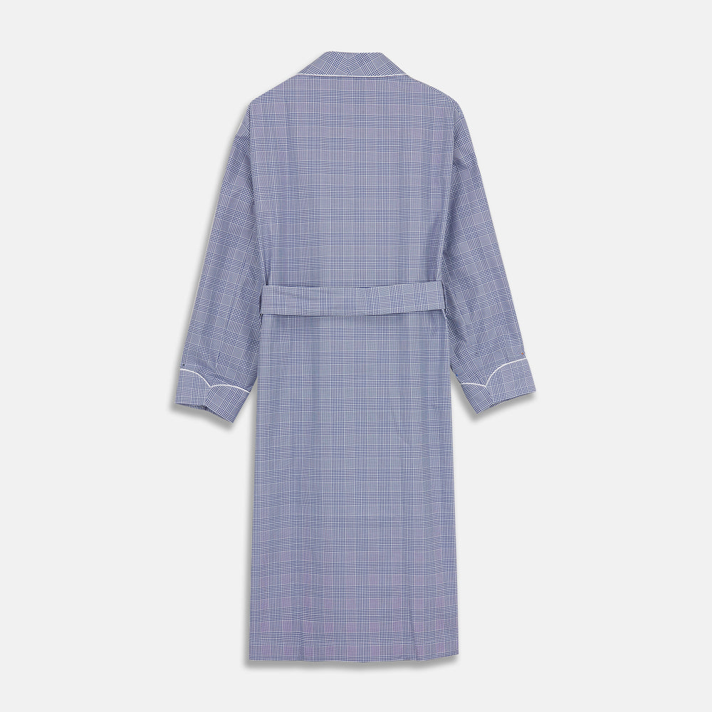 The Turnbull & Asser Navy Check Cotton Gown features long sleeves, white piping, a shawl collar, chest pocket, and matching waist belt, all in a blue plaid pattern. Shown against a plain white background.