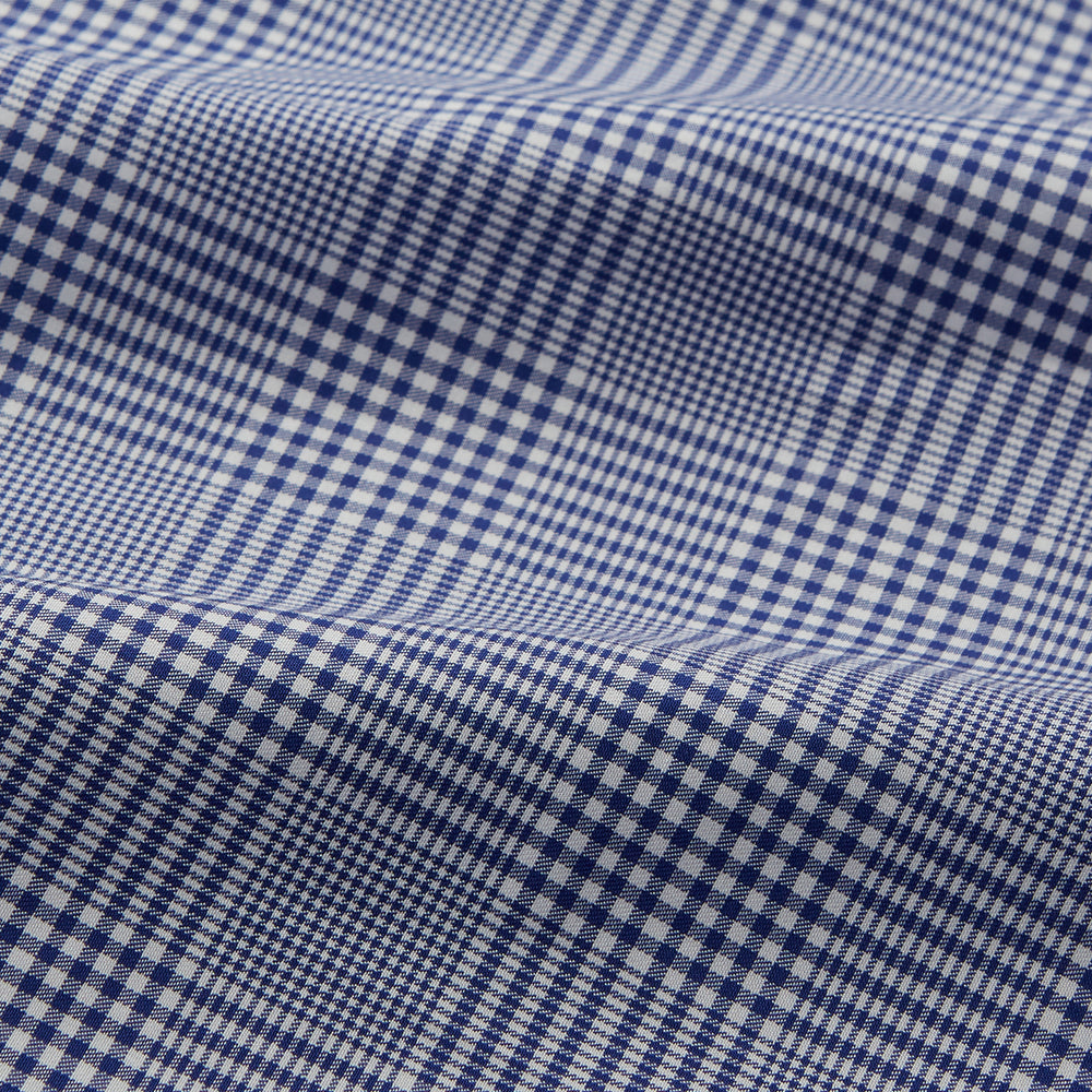 The Turnbull & Asser Navy Check Cotton Gown features long sleeves, white piping, a shawl collar, chest pocket, and matching waist belt, all in a blue plaid pattern. Shown against a plain white background.