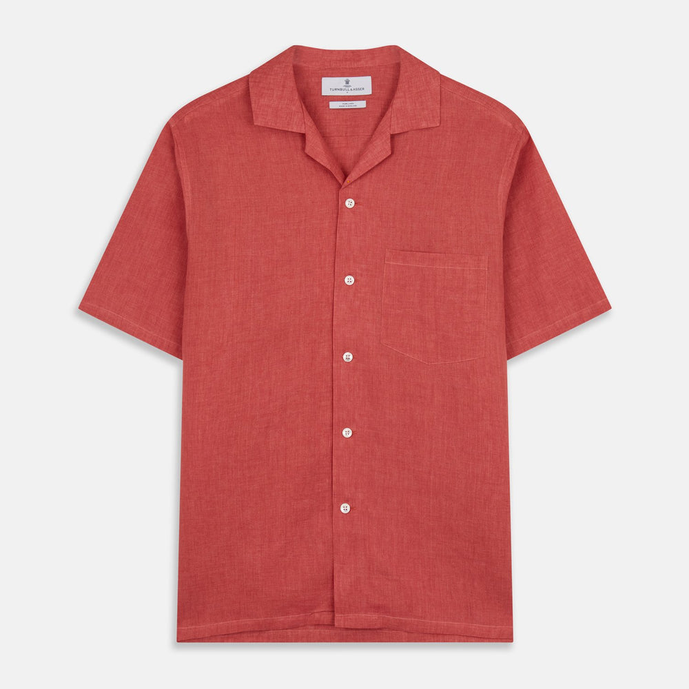 The Turnbull & Asser Crimson Delave Linen Holiday Fit Shirt features a solid brick-red hue, short sleeves, single chest pocket, and revere collar—perfect resort wear—shown laid flat on white.