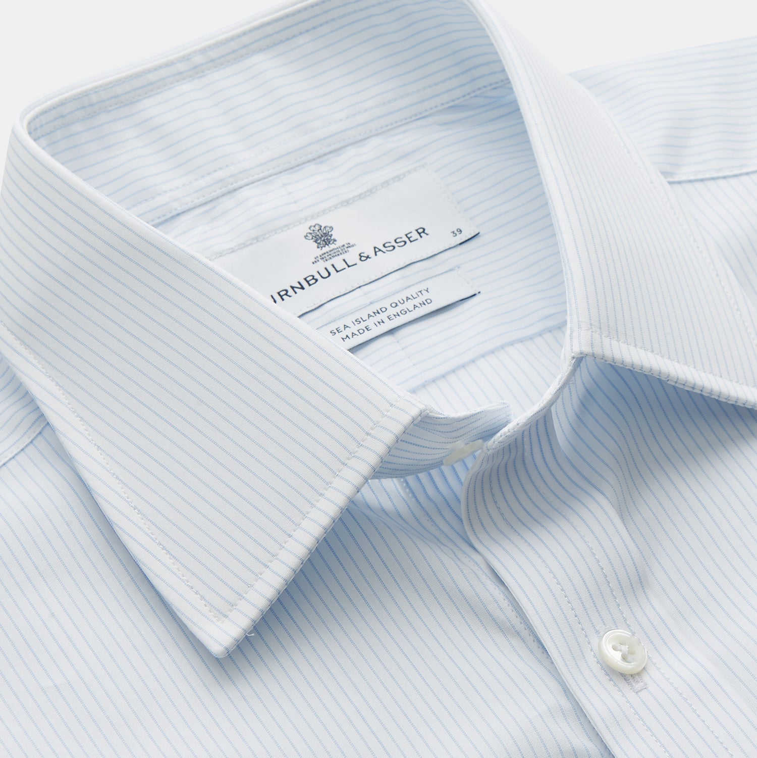 View 2 of product The Turnbull & Asser Pale Blue Stripe Regular Fit Sea Island Quality Cotton Shirt features a T&A collar and 3-button cuffs, laid flat on a white background.