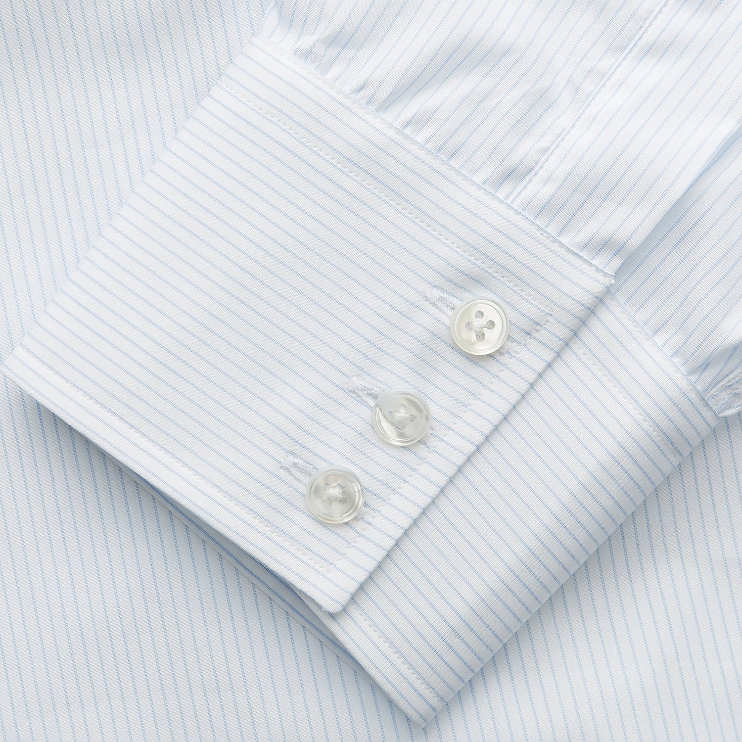 View 3 of product The Turnbull & Asser Pale Blue Stripe Regular Fit Sea Island Quality Cotton Shirt features a T&A collar and 3-button cuffs, laid flat on a white background.