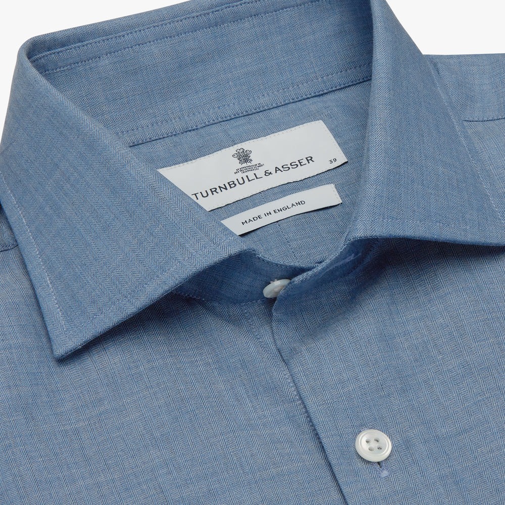 The Turnbull & Asser Blue Tailored Fit Shirt features a Kent collar, 2-button cuffs, and white buttons—a versatile men’s wardrobe essential. Laid flat on a white background.
