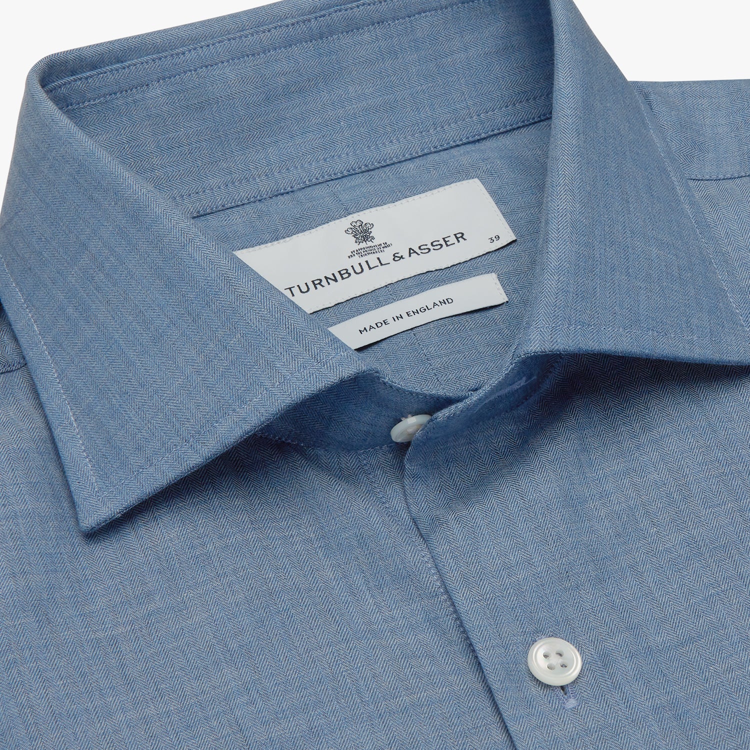 View 2 of product The Turnbull & Asser Blue Tailored Fit Shirt features a Kent collar, 2-button cuffs, and white buttons—a versatile men’s wardrobe essential. Laid flat on a white background.