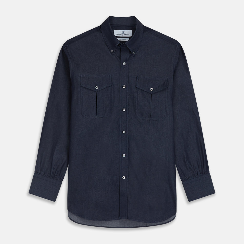 The Turnbull & Asser Navy Chambray Weekend Fit Shirt features a Dorset collar, long sleeves with 1-button cuffs, and two button-flap chest pockets. This officer’s shirt is displayed flat on a white background.