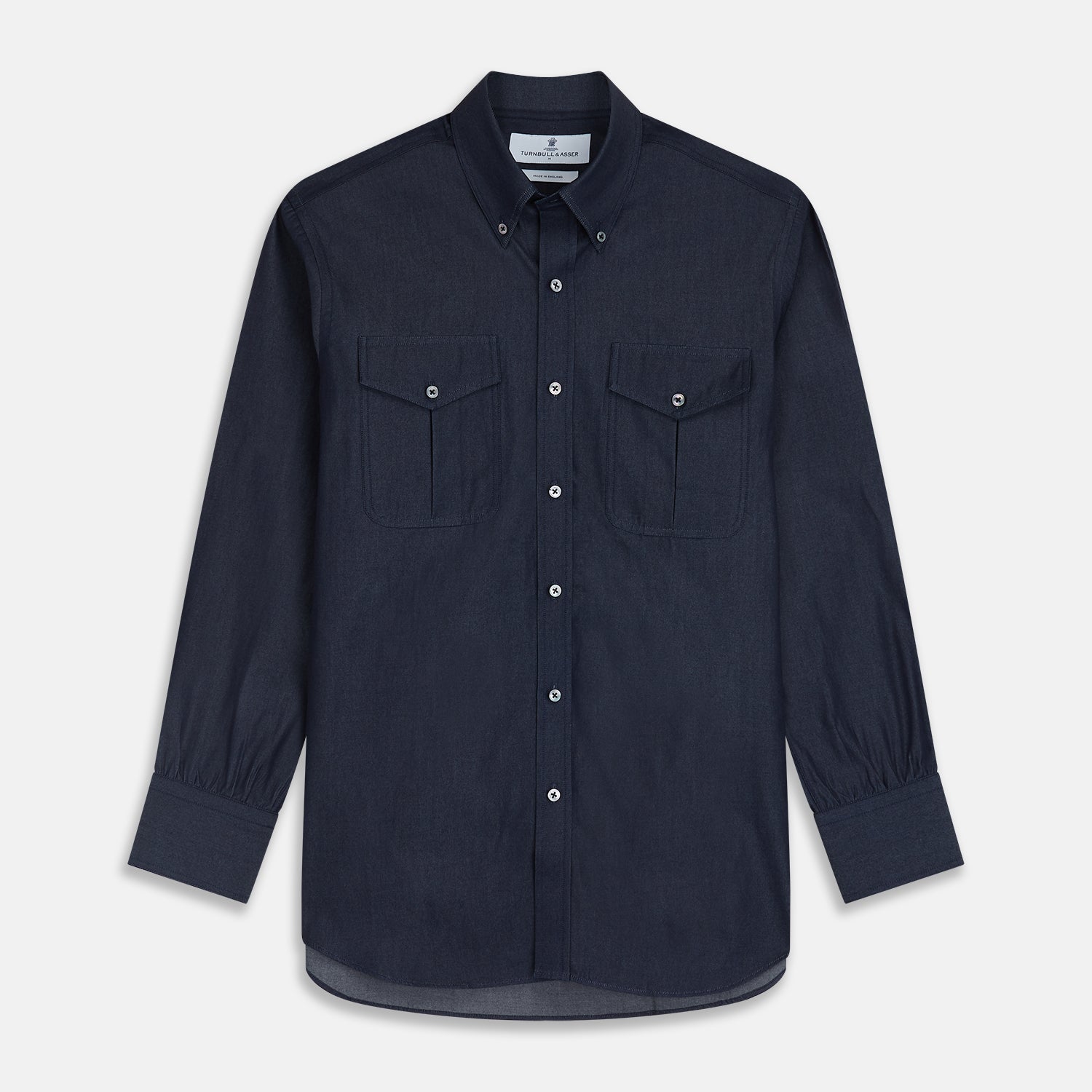View 1 of product The Turnbull & Asser Navy Chambray Weekend Fit Shirt features a Dorset collar, long sleeves with 1-button cuffs, and two button-flap chest pockets. This officer’s shirt is displayed flat on a white background.