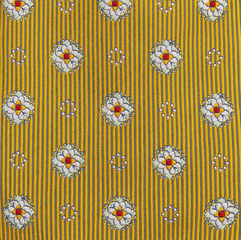 The Yellow Multi Floral Motif Silk Tie by Turnbull & Asser features subtle diagonal stripes and small white, blue, and orange floral motifs—a perfect summer palette, shown rolled up on a plain white background.