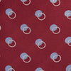 View 3 of product The Turnbull & Asser Red Multi Circle Silk Tie features small blue and white rings on red silk, making it ideal for pairing with bold shirts or adding vibrant flair to summer looks. Shown rolled at one end against a plain white background.