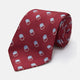 The Turnbull & Asser Red Multi Circle Silk Tie features small blue and white rings on red silk, making it ideal for pairing with bold shirts or adding vibrant flair to summer looks. Shown rolled at one end against a plain white background.