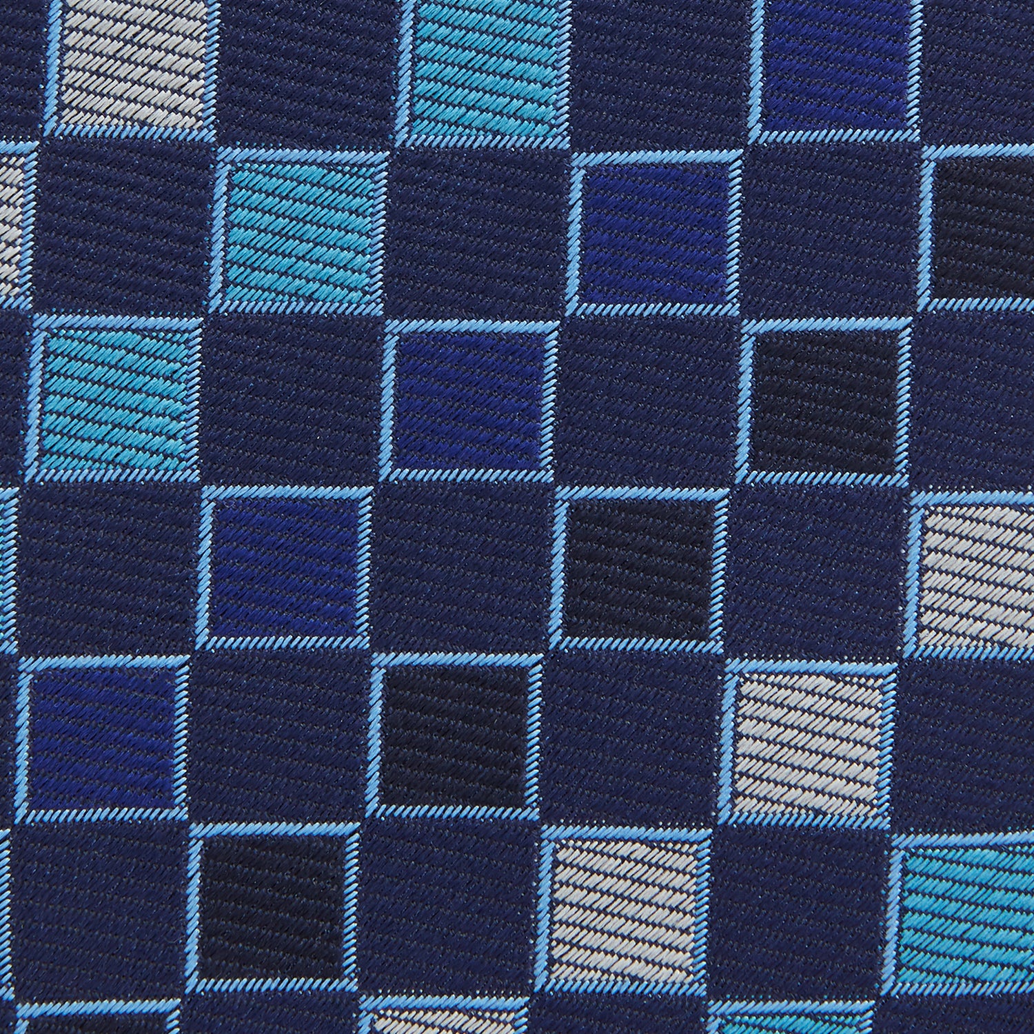 View 3 of product The Blue Multi Check Silk Tie by Turnbull & Asser features a geometric checked pattern in blue, light blue, and silver on dark navy—ideal for pairing with bold shirts.