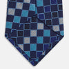 View 4 of product The Blue Multi Check Silk Tie by Turnbull & Asser features a geometric checked pattern in blue, light blue, and silver on dark navy—ideal for pairing with bold shirts.