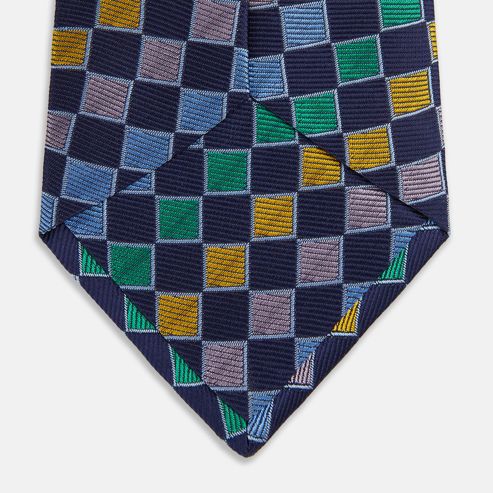 The Green Multi Check Silk Tie by Turnbull & Asser features a green checkered pattern with blue, yellow, and light purple squares on dark blue—ideal for bold shirts and a vibrant summer palette.