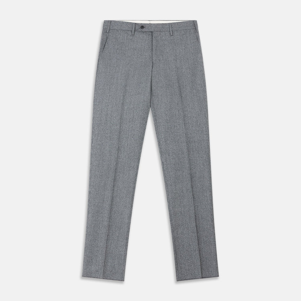 A person wears Turnbull & Asser Grey Puppytooth Wool Manson Trousers, a white dress shirt with rolled-up sleeves, and black shoes, standing against a plain beige background.