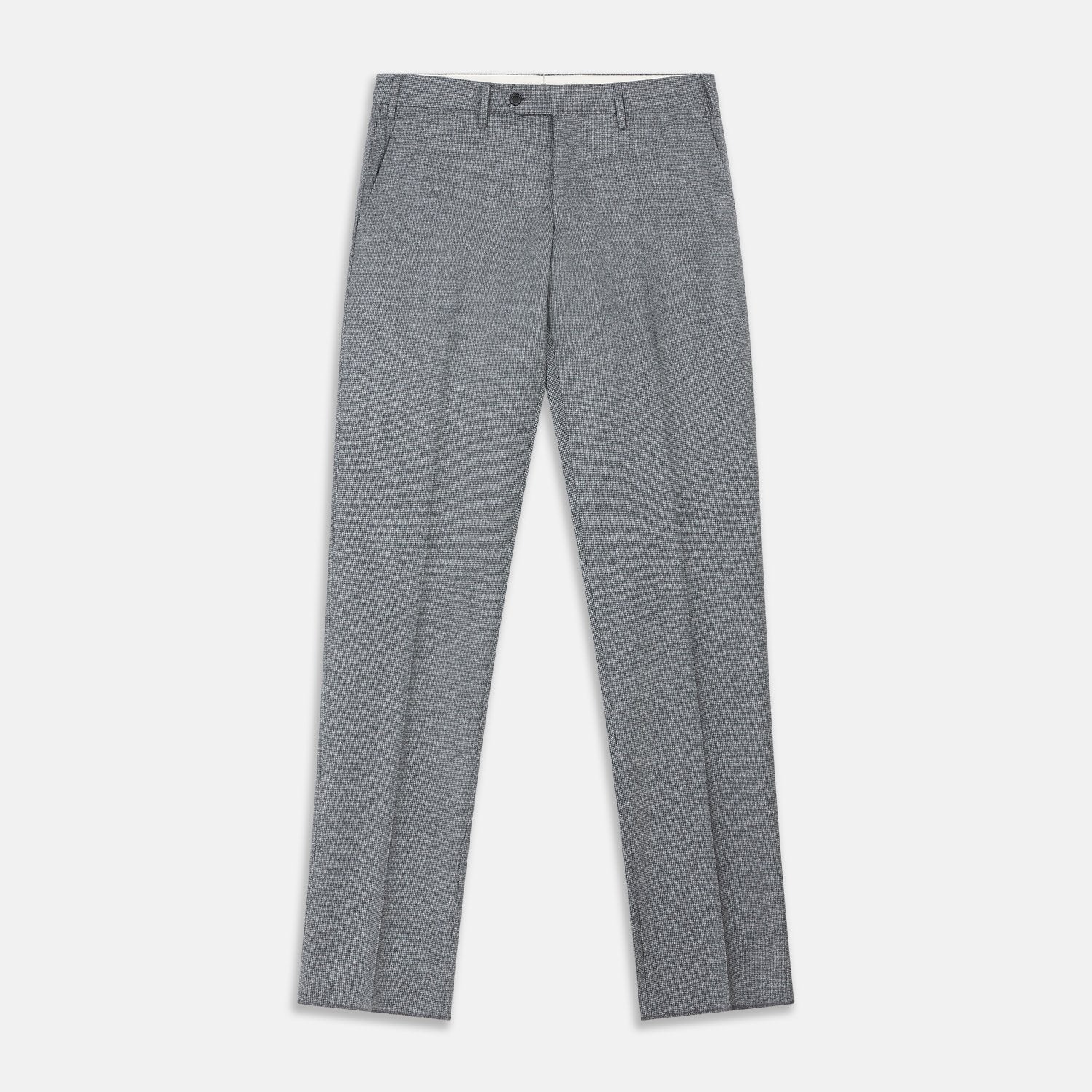 View 2 of product A person wears Turnbull & Asser Grey Puppytooth Wool Manson Trousers, a white dress shirt with rolled-up sleeves, and black shoes, standing against a plain beige background.