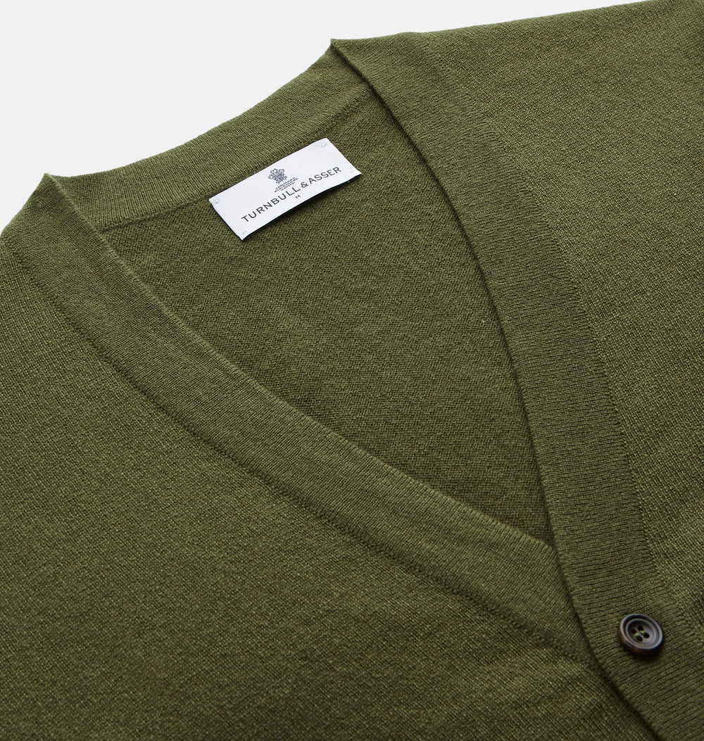 The Olive Lachlan Cashmere Cardigan by Turnbull & Asser features long sleeves, two front pockets, a V-neckline, and ribbed cuffs and hem—a smart-casual classic shown laid flat on a white background.