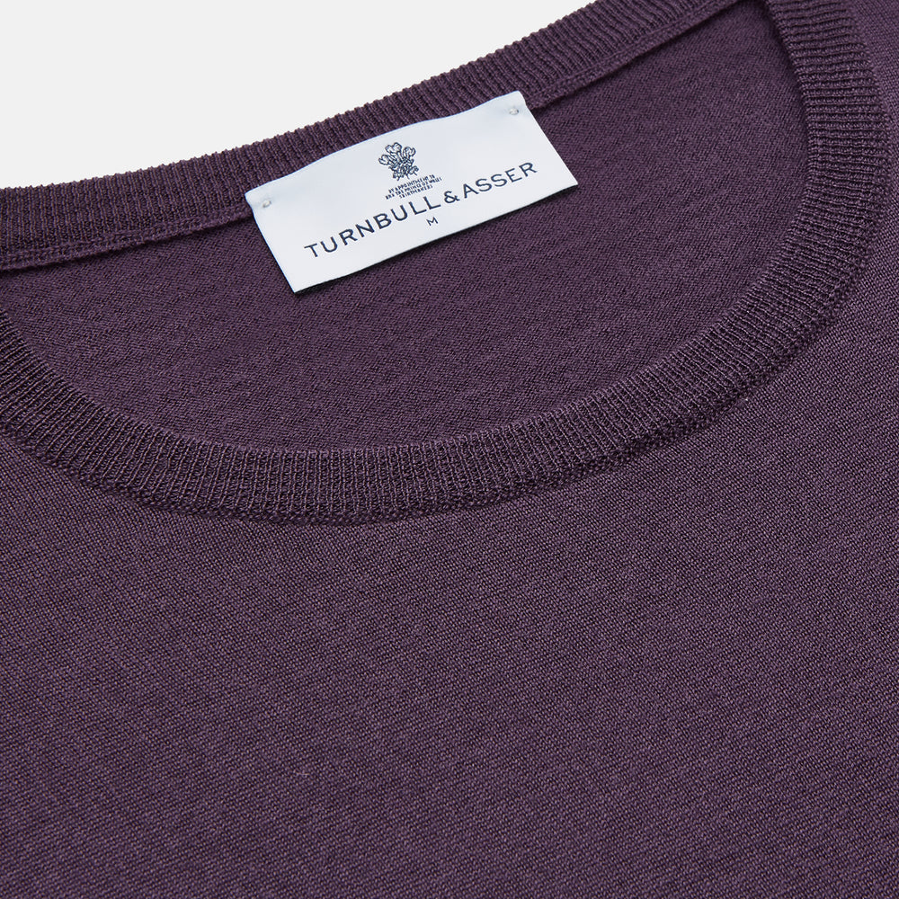 The Turnbull & Asser Plum Kingston Merino Crew Neck Jumper is a lightweight, long-sleeve sweater with ribbed cuffs and hem, shown flat on a white background. Its solid plum color and classic design offer timeless style.
