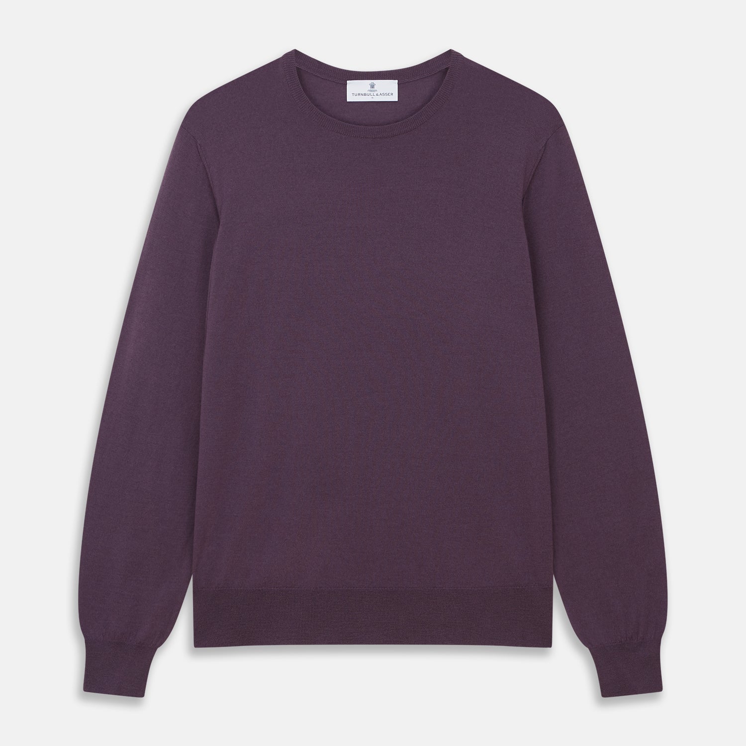 View 1 of product The Turnbull & Asser Plum Kingston Merino Crew Neck Jumper is a lightweight, long-sleeve sweater with ribbed cuffs and hem, shown flat on a white background. Its solid plum color and classic design offer timeless style.