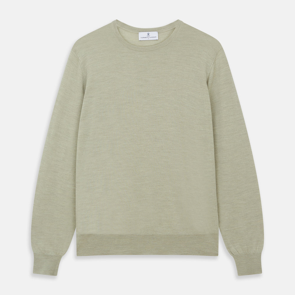 The Light Green Kingston Merino Crew Neck Jumper by Turnbull & Asser is laid flat, displaying its classic design with ribbed cuffs, hem, and neckline.