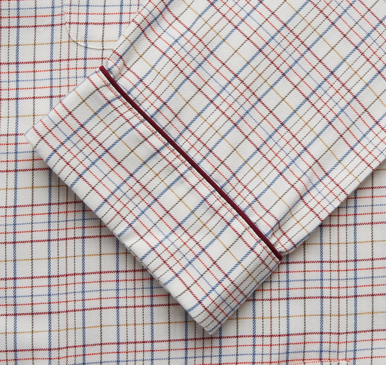 View 3 of product The Turnbull & Asser Red Multi Check Cotton-Cashmere Modern Pyjama Set, made in England, features a long-sleeve button-up shirt and pants in red and gray plaid with dark piping, crafted from soft Italian cotton-cashmere.