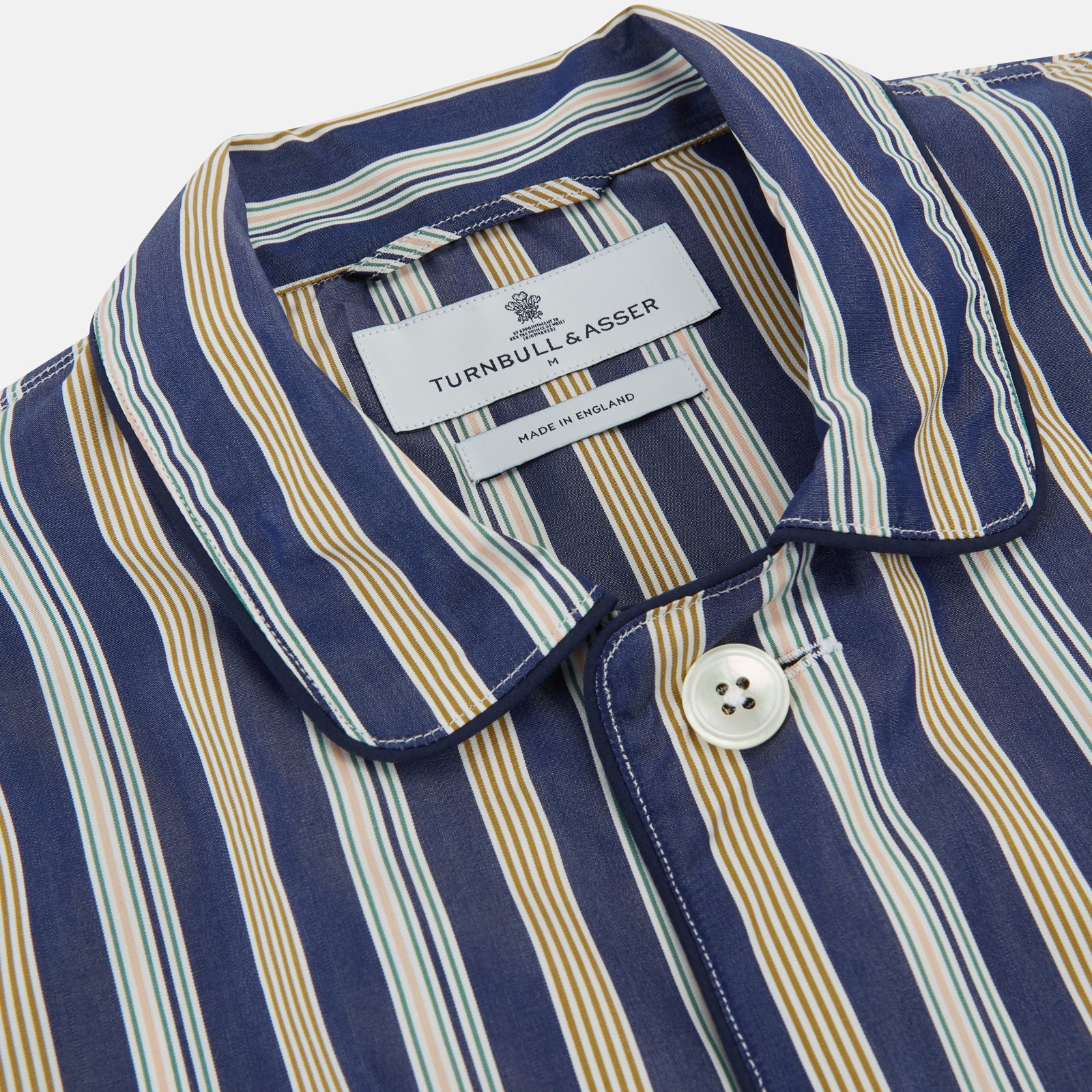 View 2 of product Turnbull & Asser's Blue Multi Stripe Cotton Modern Pyjama Set features a camp collar shirt with white buttons, front pocket, and long sleeves. Both pieces showcase classic blue and beige stripes for a timeless look.