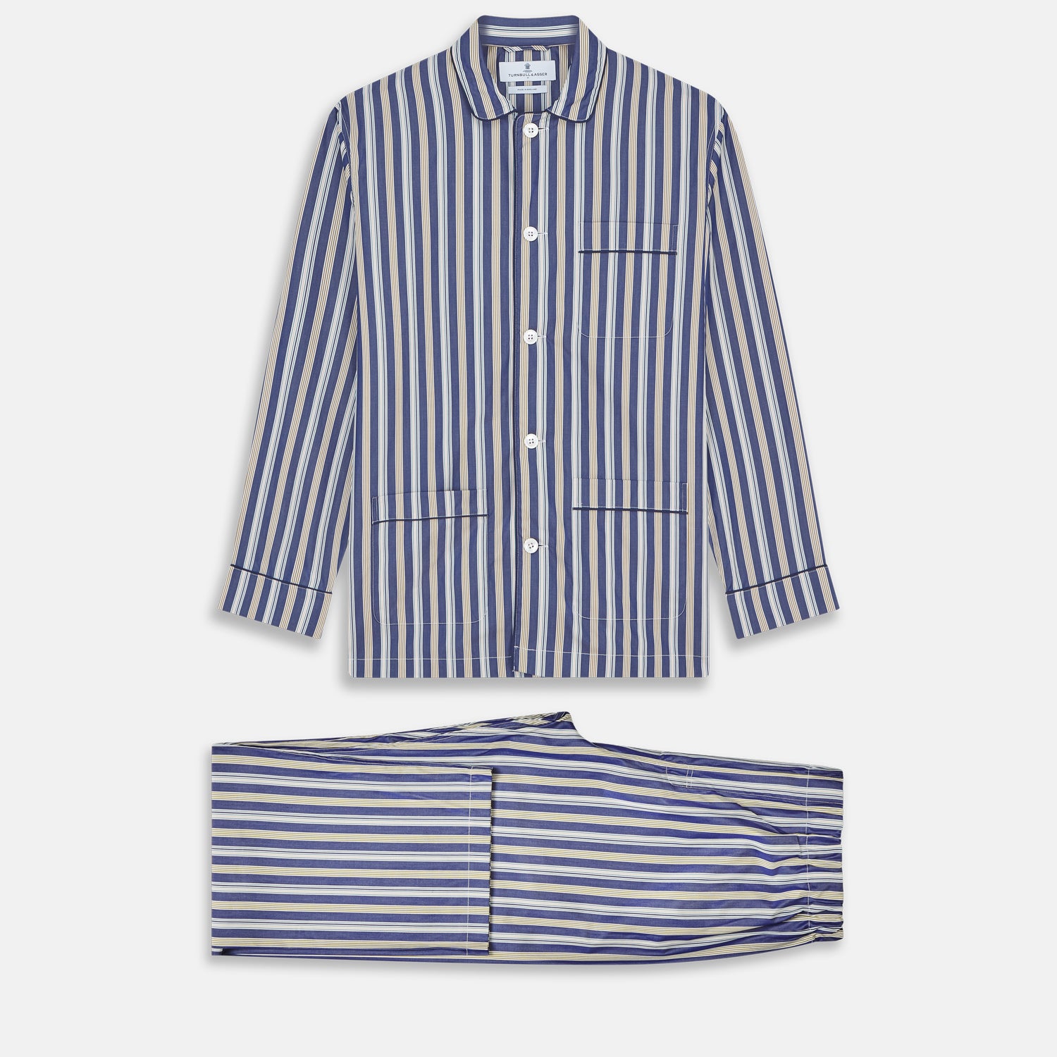 View 1 of product Turnbull & Asser's Blue Multi Stripe Cotton Modern Pyjama Set features a camp collar shirt with white buttons, front pocket, and long sleeves. Both pieces showcase classic blue and beige stripes for a timeless look.