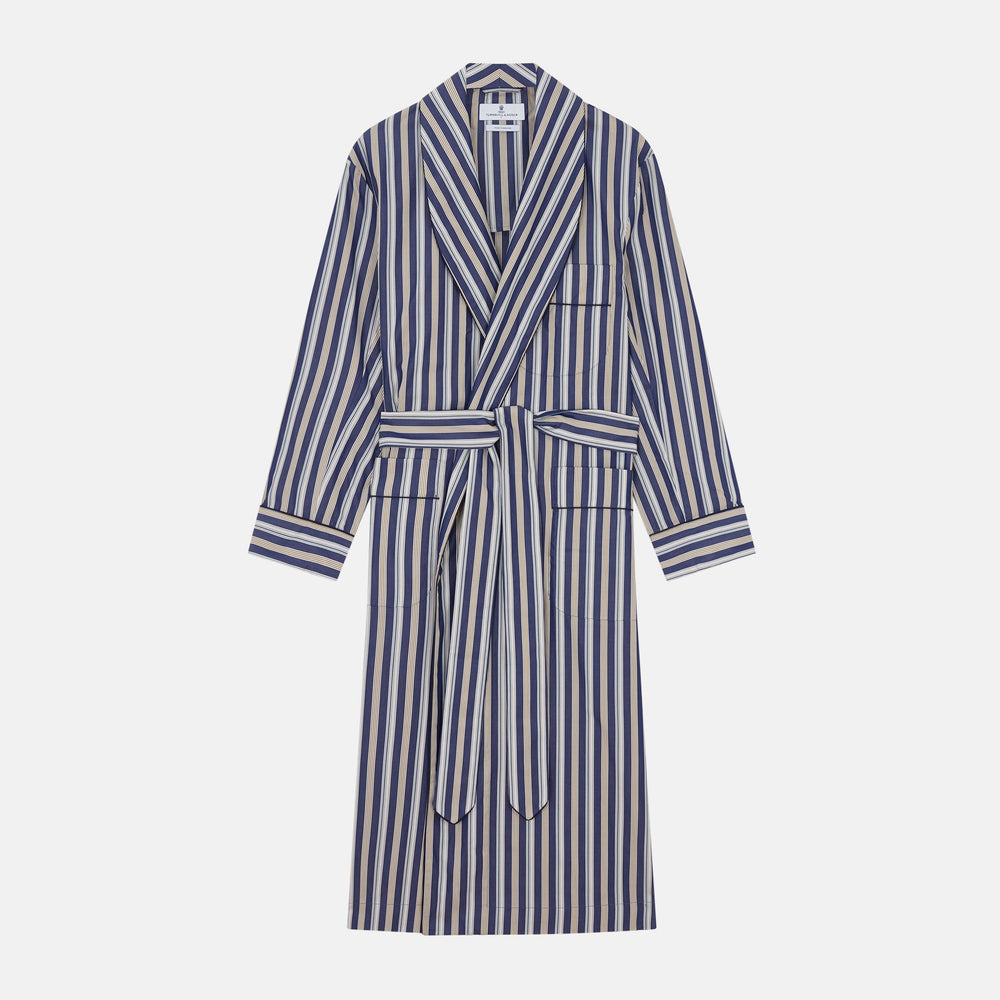 The Turnbull & Asser Blue Multi Stripe Cotton Gown features blue and white vertical stripes, long sleeves, a shawl collar, front pockets, and a matching waist tie, shown on a plain white background.