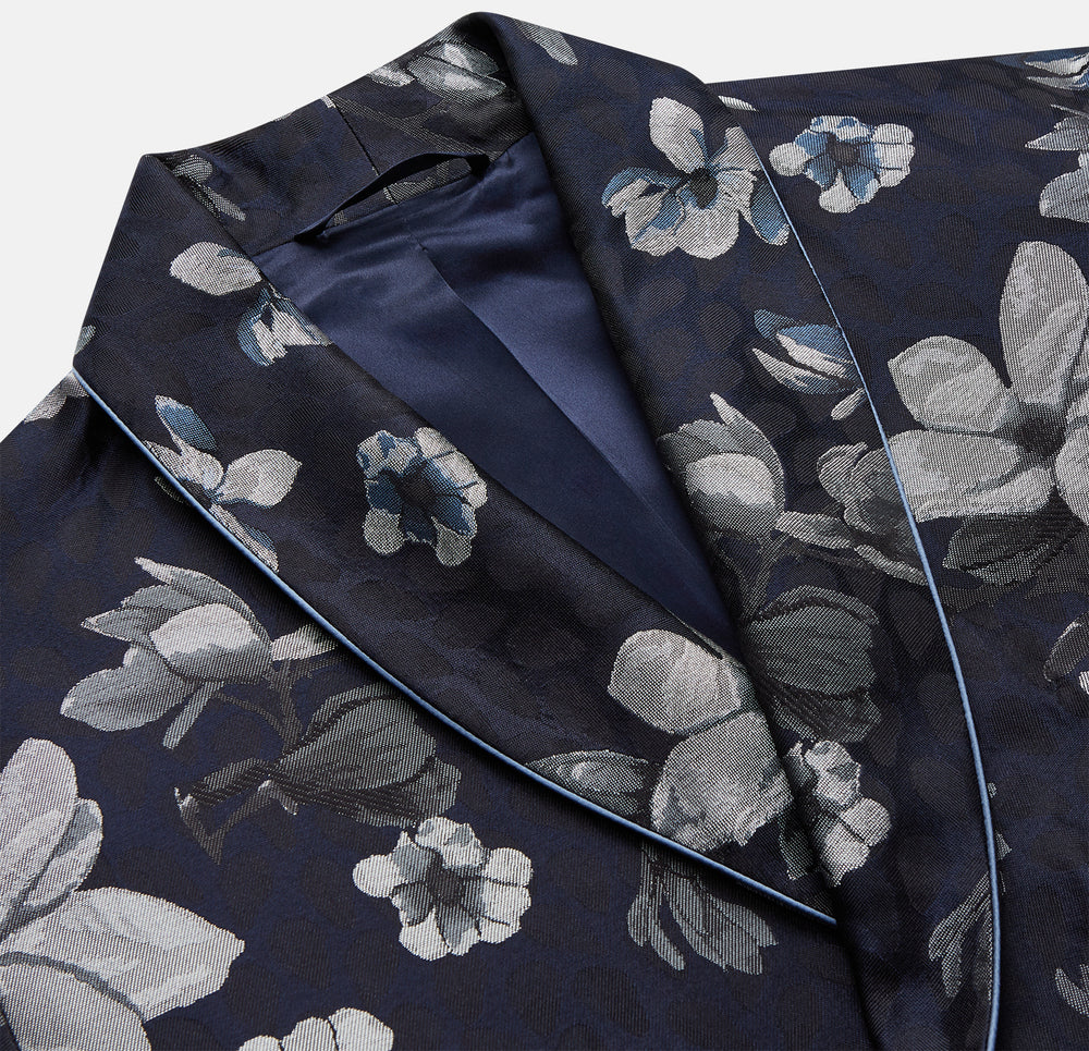 The Navy Floral Silk Jacquard Pierce Gown by Turnbull & Asser features a shawl collar, long sleeves, matching fabric belt, and elegant grey and blue floral design.