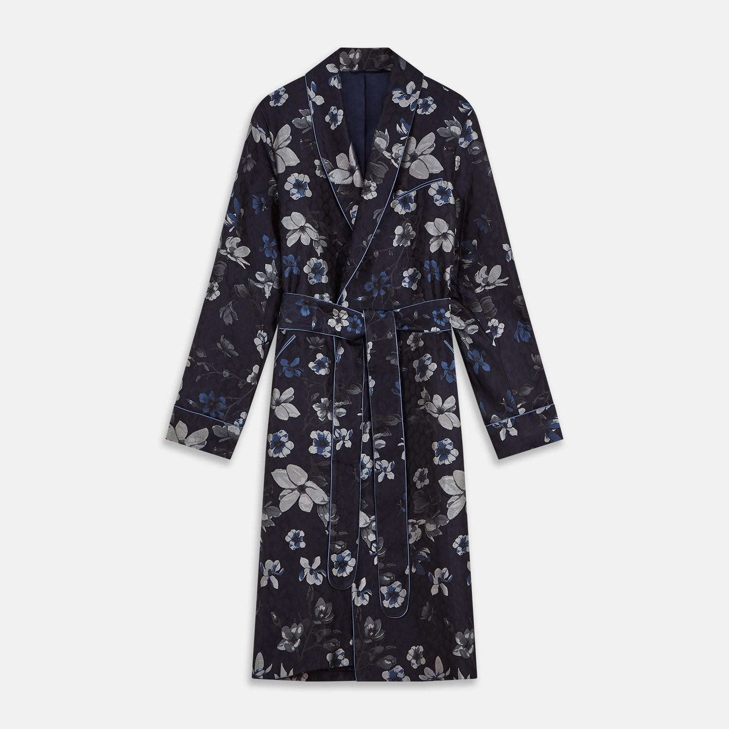 View 1 of product The Navy Floral Silk Jacquard Pierce Gown by Turnbull & Asser features a shawl collar, long sleeves, matching fabric belt, and elegant grey and blue floral design.