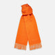 The Turnbull & Asser Orange Purled Fringe Cashmere Scarf is shown neatly arranged on a white background, featuring soft, thick cashmere with fringe at both ends and a subtle embroidered logo near one edge.