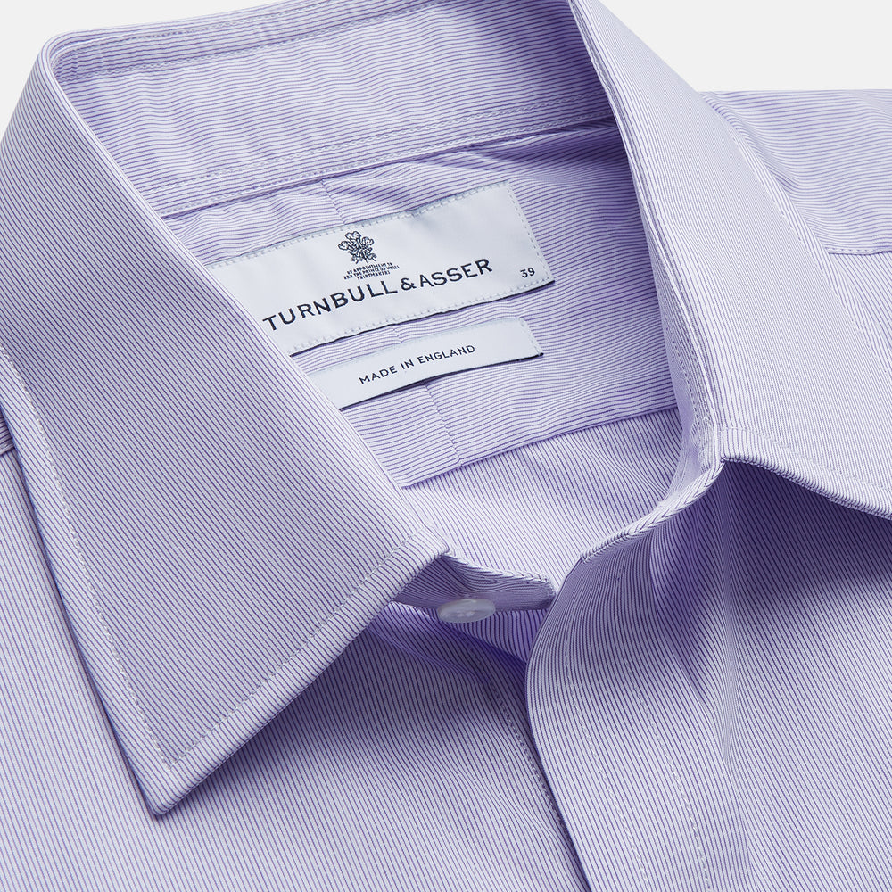 The Turnbull & Asser Purple Hairline Stripe Regular Fit Twill Shirt features a T&A collar, double cuffs, long sleeves, and white buttons, shown laid flat on a white background.
