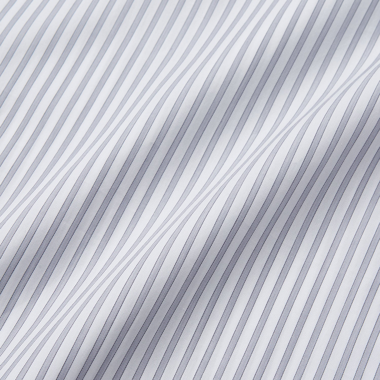 View 5 of product A man wearing the Turnbull & Asser Grey Multi Stripe Regular Fit Twill Shirt with T&A Collar and Double Cuffs stands against a beige background, one hand in his pocket, looking at the camera.