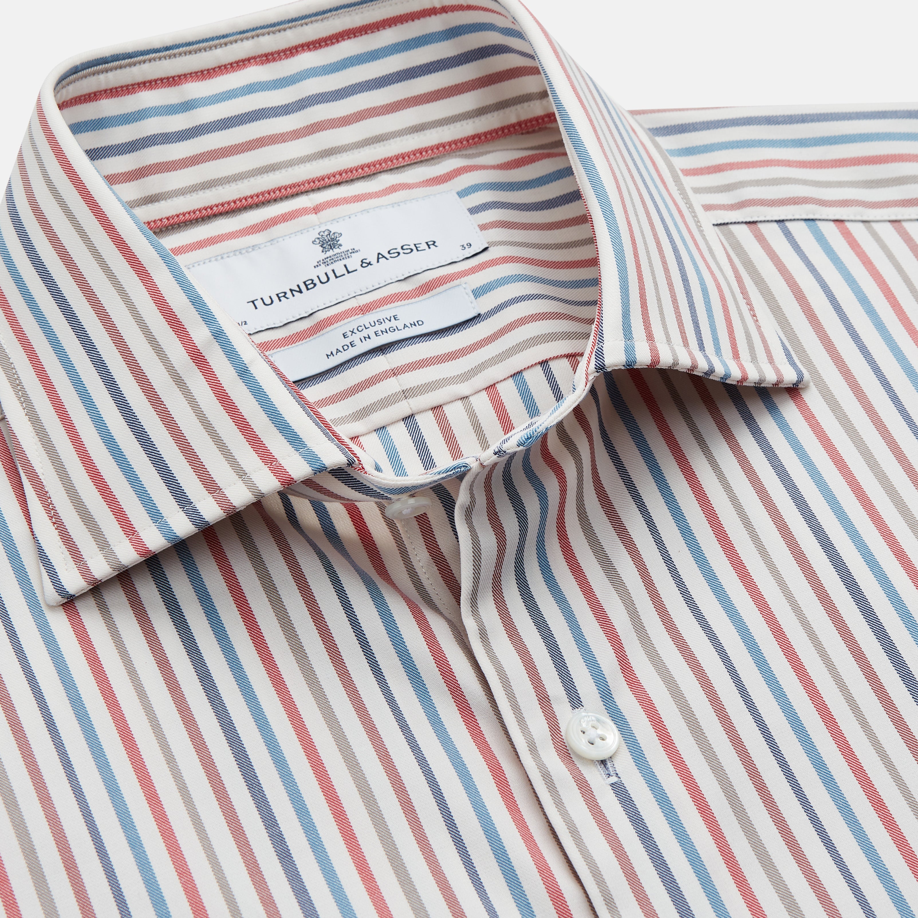 View 2 of product The Turnbull & Asser Burgundy Multi Stripe Tailored Fit Shirt features a Kent collar and 2 button cuffs, with vertical stripes on a light background. The shirt is neatly laid flat on a white surface.